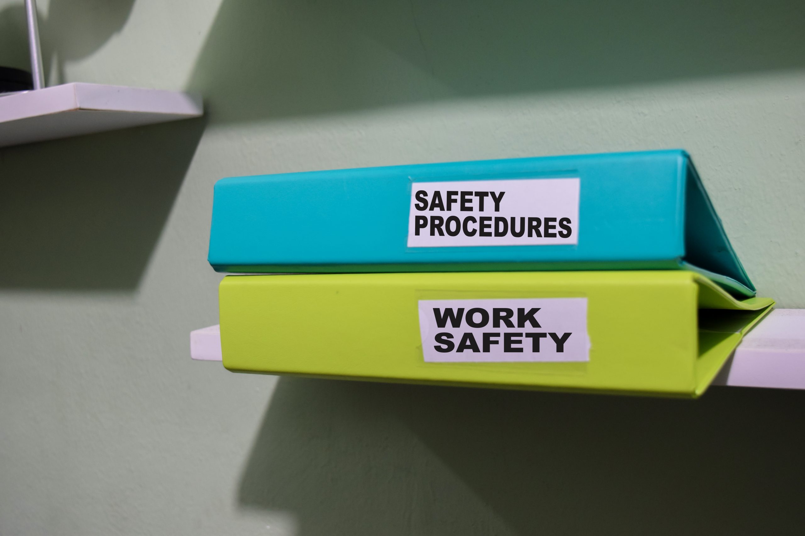Organised safety folders labeled for WHS compliance and OHS manual storage.